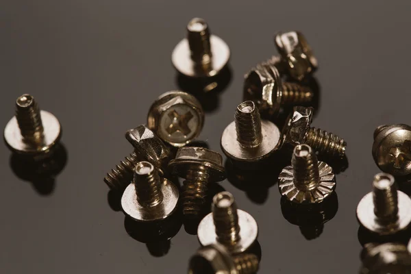 Screws for a computer on dark background — Stock Photo, Image