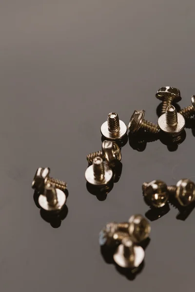 Screws for a computer on dark background — Stock Photo, Image