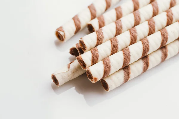 Rolos de wafer com recheio de porca em um fundo de espelho de luz — Fotografia de Stock