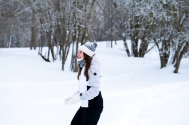 Karlı bir kış parkında koşan bir kadın. Açık hava eğlencesi, soğuk sezon aktivitesi, pozitif enerji, fitness rutini, sağlıklı alışkanlıklar ve aktif yaşam tarzı konsepti