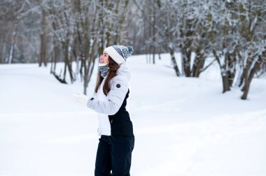 Karlı bir kış parkında koşan bir kadın. Açık hava eğlencesi, soğuk sezon aktivitesi, pozitif enerji, fitness rutini, sağlıklı alışkanlıklar ve aktif yaşam tarzı konsepti