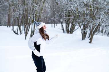 Karlı bir kış parkında koşan bir kadın. Açık hava eğlencesi, soğuk sezon aktivitesi, pozitif enerji, fitness rutini, sağlıklı alışkanlıklar ve aktif yaşam tarzı konsepti