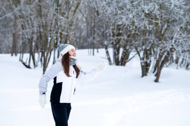 Karlı bir kış parkında koşan bir kadın. Açık hava eğlencesi, soğuk sezon aktivitesi, pozitif enerji, fitness rutini, sağlıklı alışkanlıklar ve aktif yaşam tarzı konsepti