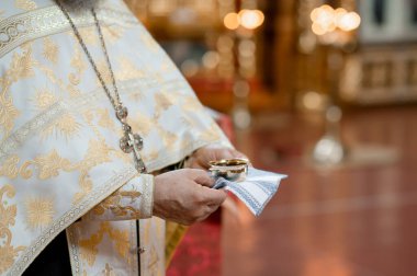 Rahiplerin ellerini altın işlemeli beyaz cübbeyle kapayın. Katedral dini gelenek ve ruhani ayinde ayin için kutsal kadehle birlikte şarap taşıyın.