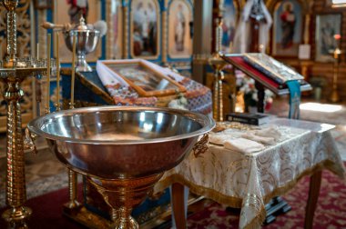 Kutsal su kasesi ve vaftiz töreni için hazırlanmış dini eşyalarla katedralin iç manzarası. Miras geleneği ve ruhani atmosfer kavramsal çekimi.