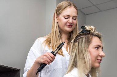 Usta bir kadına saç eklentisi yapar. Sürecin kapanışı.