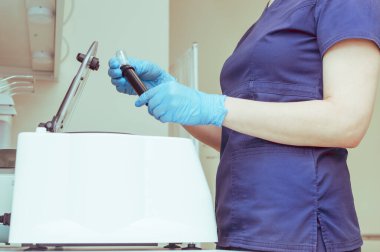 Plazma terapi santrifüjünde test tüpleri olan bir doktor.