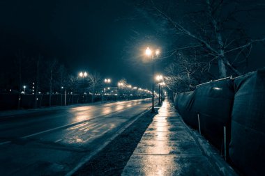 Boş karanlık ve ıslak şehir yolu yağmurdan sonra gece