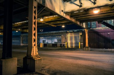Yükseltilmiş CTA tren rayları, antika endüstriyel depoları ve fabrikaları olan karanlık ve ürkütücü Chicago şehir sokak manzarası