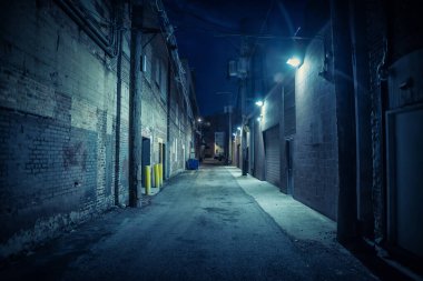 Dark and eerie urban city alley at night clipart