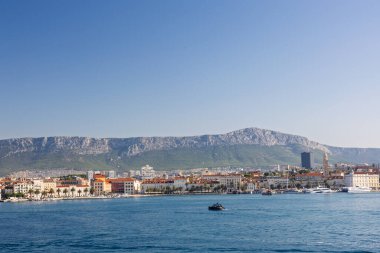 BÖLÜM, CROATIA, 09.06.2025: Akdeniz 'in canlı kıyı kasabası çevresi bir dağ zeminiyle, canlı denizle ve canlı bir atmosferle çevrili.