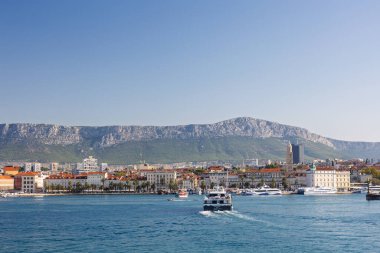 BÖLÜM, CROATIA, 09.06.2025: Akdeniz 'in canlı kıyı kasabası çevresi bir dağ zeminiyle, canlı denizle ve canlı bir atmosferle çevrili.