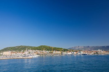 BÖLÜM, CROATIA, 09.06.2025: Akdeniz 'in canlı kıyı kasabası çevresi bir dağ zeminiyle, canlı denizle ve canlı bir atmosferle çevrili.