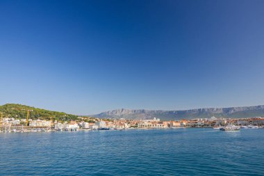 BÖLÜM, CROATIA, 09.06.2025: Akdeniz 'in canlı kıyı kasabası çevresi bir dağ zeminiyle, canlı denizle ve canlı bir atmosferle çevrili.