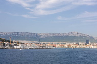 Akdeniz mimarisinin canlı kıyı kasabası çevresi bir dağ zeminiyle, canlı bir denizle ve canlı bir atmosferle çevrili..