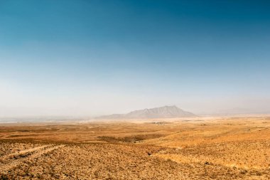 Dağlı çöl. Afganistan 'da arka planda dağlar olan bir çöl manzarası.