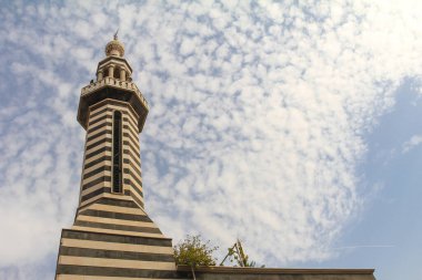 Çarpıcı bir mimari yapı çizgili desenleri barındırıyor dinamik mavi gökyüzüne uzanan bulutlarla. Kültürel mirasın ve eşsiz tasarımın mükemmel bir tasviri..