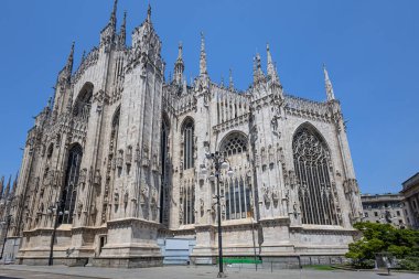 Milan 'ın Duomo' sunun dış görünüşü, süslü taş oymaları, yükselen kuleleri ve görkemli kemerleri olan ikonik bir Gotik katedrali. Mimarlık, seyahat, miras ve şehir simgesi temaları için ideal.