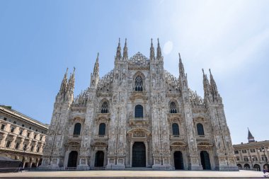 Milan 'ın Duomo' sunun dış görünüşü, süslü taş oymaları, yükselen kuleleri ve görkemli kemerleri olan ikonik bir Gotik katedrali. Mimarlık, seyahat, miras ve şehir simgesi temaları için ideal.