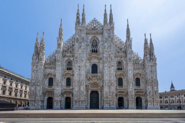 Milan 'ın Duomo' sunun dış görünüşü, süslü taş oymaları, yükselen kuleleri ve görkemli kemerleri olan ikonik bir Gotik katedrali. Mimarlık, seyahat, miras ve şehir simgesi temaları için ideal.