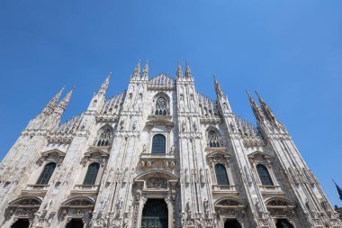 Milan 'ın Duomo' sunun dış görünüşü, süslü taş oymaları, yükselen kuleleri ve görkemli kemerleri olan ikonik bir Gotik katedrali. Mimarlık, seyahat, miras ve şehir simgesi temaları için ideal.