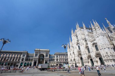 MILAN, ITALY, 06.19.2025: Gotik Duomo heykelleri etrafındaki Milano tarihi meydanı turistler, mimari ve büyük taş işleri sergiliyor. İtalya 'da aydınlık bir gün, ünlü bir kent simgesi etrafında kültür, miras ve şehir yaşamını yakalıyor..