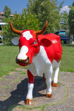 CASLANO, SWitzERLAND, 06.20.2025: parlak kırmızı ve beyaz inek heykeli. Etkileşimli sergi ve çikolata imalatı tarihi ve Çikolata Alprose 'un 1957' den beri başarı öyküsü hakkında her şey..