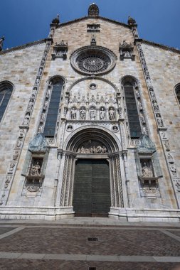 Büyük bir Gotik katedral cephesi büyük bir gül penceresi, karmaşık taş oymalar ve uzun kemerler. Zengin mimari ayrıntılar, temiz mavi gökyüzüne karşı miras, din ve tarihi işçiliği yansıtıyor..