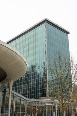 ROGASKA SLATINA, SLOVENIA, 01.03.2026: Çağdaş cam ofis kompleksi karlı bir kampüste kavisli bir kule ve uzun bir kuleye sahiptir. Mimarlık, işletme ve eğitim için ideal.