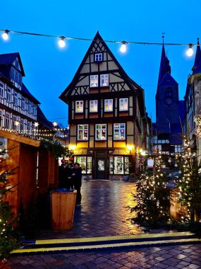 Quedlinburg, Almanya 'da Noel' de güzel aydınlatılmış yarı ağaçlandırılmış evler ve kaldırım taşlı caddeler görülür. Şenlikli sicim ışıkları bölgeyi süsleyerek sıcak ve davetkar bir atmosfer yaratıyor.. 