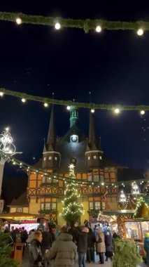 Wernigerode, Almanya ahşap tezgahlar ve şenlikli dekorasyonlarla hareketli bir Noel pazarına ev sahipliği yapıyor. Sivri kuleleri olan tarihi ahşap çerçeveli bina. 