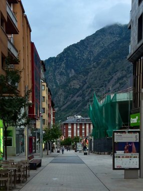 Andorra la Vella 'nın tarihi merkezinde, renkli cepheli modern binaların yer aldığı yaya caddesi. Engebeli dağ formları
