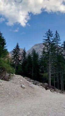  İtalya 'nın Dolomitleri' nde yuva yapmış olan Braies Gölü 'nde engebeli, yüksek dağlara karşı durgun turkuaz suları bulunuyor. Kıyı, yemyeşil kozalaklı ağaçlarla çevrili, çakıl taşlı. Kayalık kayalıklar belirgin.