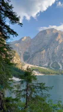 İtalya 'nın Dolomitler kentinde yer alan Braies Gölü' nde yoğun ve gür çam ormanlarıyla çevrili kristal berraklığında turkuaz su bulunur. Yüksek kireçtaşı dağları engebeli dokuları ile çarpıcı bir zemin oluşturur parlak mavi gökyüzü altında dağınık bulutlar.