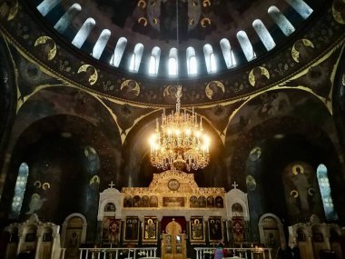 Kiev-Pechersk Lavra, Kiev, Ukrayna 'da bir kilisenin iç dekorasyonu. Uzay, kubbeli bir tavandan sarkan büyük, altın bir avizeye sahiptir. Dairesel pencereler kubbeyi kaplıyor, doğal ışığın filtrelemesini sağlıyor..
