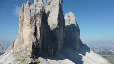 Lavaredo 'nun Üç Tepesi Yürüyüş Yolu' nun hava görüntüsü. Lavaredo 'nun Üç Tepesi' nin dramatik hava manzarası, Dolomitler, İtalya 'da yer almaktadır. Kireçtaşı oluşumları keskin bir şekilde yükseliyor, katıksız yüzler engebeli araziye gölge düşürüyor..