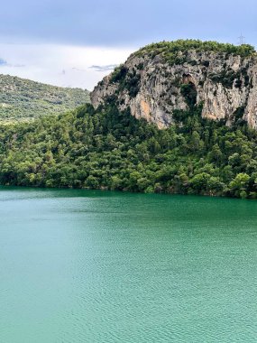 Su deposunun zümrüt yeşili suları engebeli, ağaçlarla kaplı kireçtaşı bir uçurumun altında. Uçurumun yamacı boyunca açıkta kalan kaya ve yoğun bitki örtüleri bulunur. Bölge Talarn Barajı, ayrıca Sant Antoni Barajı olarak da bilinir, İspanya 'da bulunur..