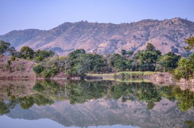 Udaipur 'dan Kumbalgarh Kalesi, Rajasthan, Hindistan' a giden kayalık arazide kıvrılan tatlı su nehirinin manzarası.