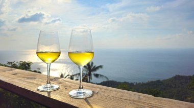 Gün batımında iki bardak beyaz şarap okyanus manzarası, Ada Ko Tao, Surat Thani, Tayland, Güneydoğu Asya.  