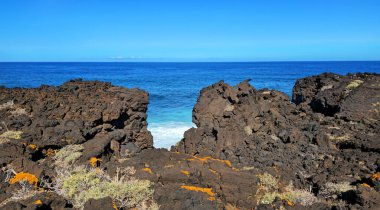 Arka planda Atlantik Okyanusu, Ada El Hierro, Kanarya Adaları, İspanya ve Avrupa 'da volkanik kaya oluşumları.