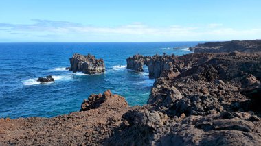 West coast with volcanic rock arch over blue Atlantic Ocean water, Island El Hierro, Canary Islands, Spain, Europe.