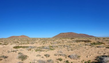 Montana del Mojon ve La Aguja Grande Dağı, La Graciosa Adası, Kanarya Adaları, İspanya, Avrupa ile çorak çöl manzarası. Solunda Montana del Mojon, sağında La Aguja Grande Dağı, Kanarya Adası, La Graciosa
