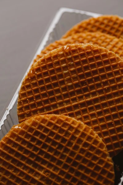 Waffles com caramelo em um fundo preto close-up — Fotografia de Stock