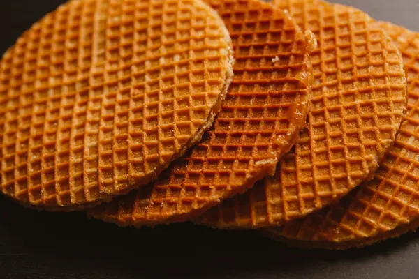 Frische Waffeln mit Karamellkeksen auf schwarzem Hintergrund — Stockfoto