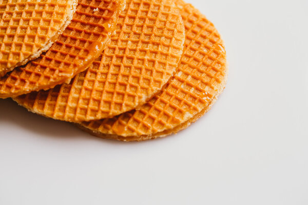 свежие вафли с карамельным печеньем на белом фоне
