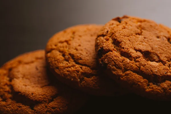 Frische Kekse mit Schokolade auf dunklem Hintergrund — Stockfoto