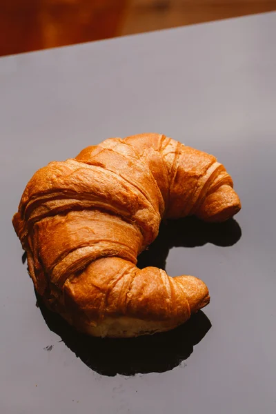 Frisches Croissant aus dem Blätterteig auf schwarzem Hintergrund — Stockfoto