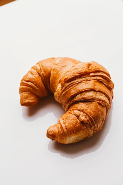 Croissant fresco da massa folhada em um fundo branco — Fotografia de Stock