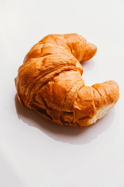 Croissant fresco da massa folhada em um fundo branco — Fotografia de Stock