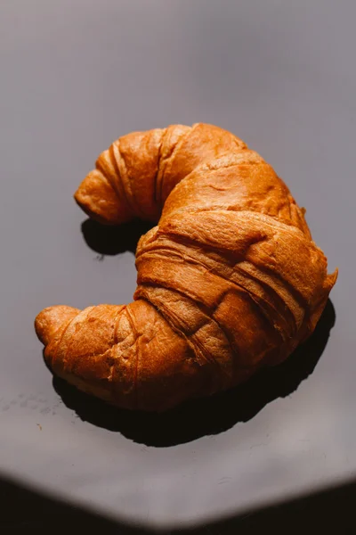 Čerstvý croissant z listového těsta na černém pozadí — Stock fotografie